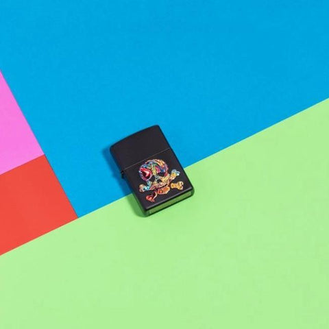 Lifestyle image of Texture Skull Design Windproof Lighter laying flat on neon coloured background