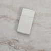 Lifestyle image of Slim® Mercury Glass Windproof Lighter laying on a marble surface