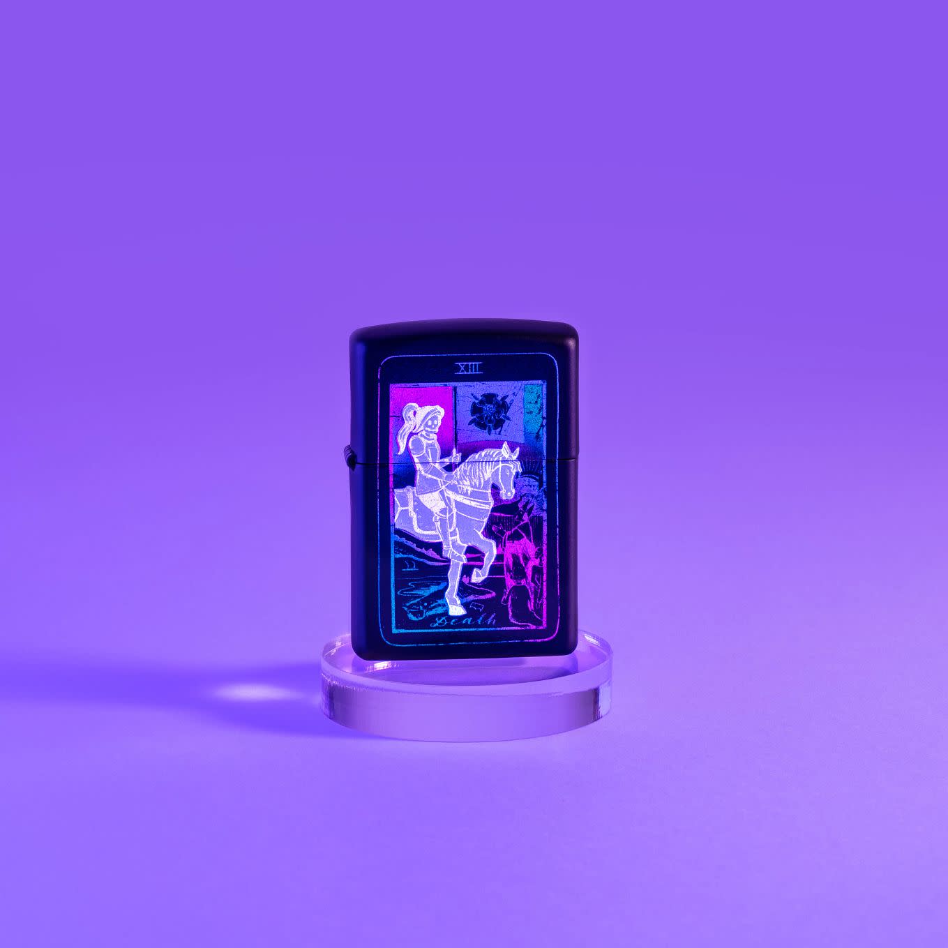 Lifestyle image of Black Light Tarot Card Design Black Matte Windproof Lighter glowing under a black light.