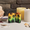 Lifestyle image of two Cannabis Design 540 Color Windproof Lighters, one showing the front and the other showing the back of the lighter. The lighters are standing on a side stand with candles and a burning incent in the background.