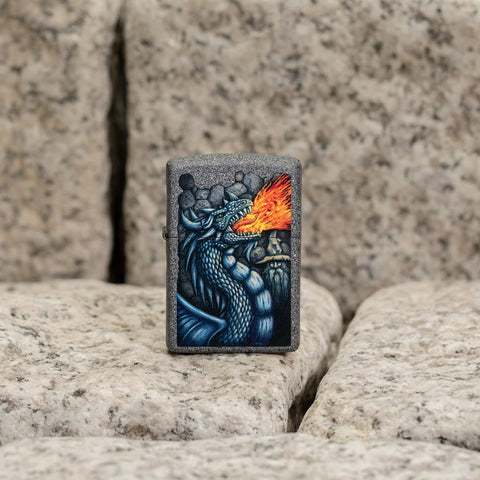 Lifestyle image of Fiery Dragon Design Iron Stone Windproof Lighter standing on cobblestone. 