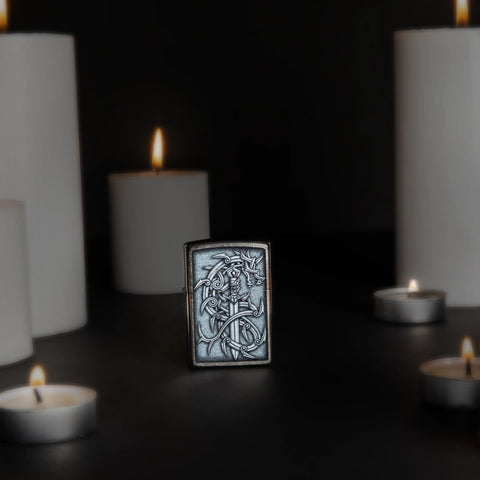 Lifestyle image of Medieval Dragon and Blade Street Chrome Windproof Lighter standing with lit candles.